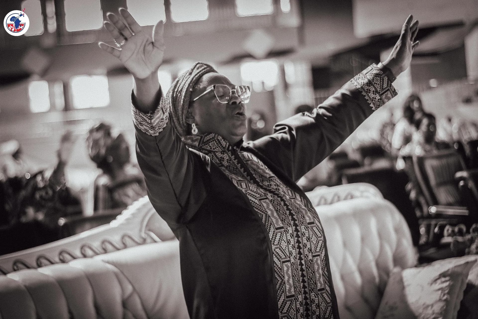 Women in worship with arms raised at the WIGPA 25th anniversary