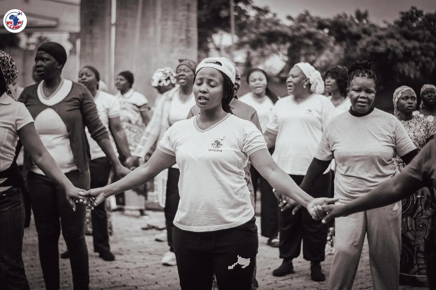Women joined hand in hand in a covenant circle at the WIGPA 25th anniversary.